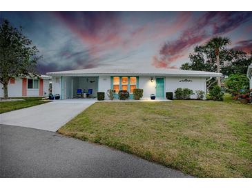 Cute Florida home with teal door, carport, and well-manicured lawn at 555 Circlewood Dr # T10, Venice, FL 34293