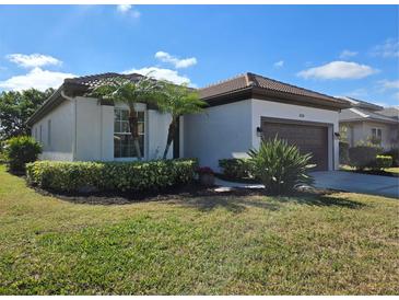 One-story home with brown roof, attached garage, and landscaped yard at 624 Silk Oak Dr, Venice, FL 34293