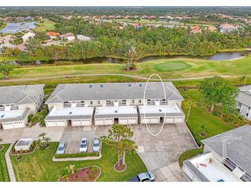 Aerial view of condo building, showing building exterior, landscaping, and golf course at 934 Capri Isles Blvd # 111, Venice, FL 34292