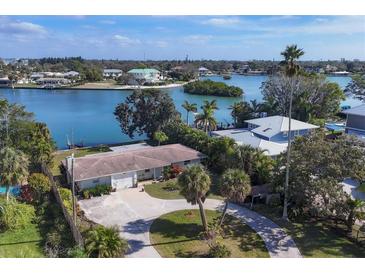 Aerial view of waterfront home with circular driveway, offering peaceful water views at 107 Louella Ln, Nokomis, FL 34275