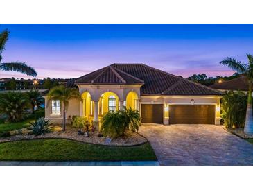 Beautiful home exterior with landscaping and a two car garage at 20450 Passagio Dr, Venice, FL 34293