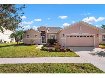 Single-story house with a two-car garage and landscaped lawn at 2558 Hobblebrush Dr, North Port, FL 34289