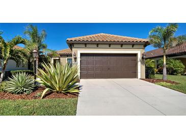 Single-story home with a two-car garage and landscaped front yard at 295 Cassano Drive, Nokomis, FL 34275