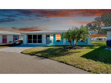 Charming single story home with teal accents and well-manicured lawn at 411 Circlewood Dr # I2, Venice, FL 34293