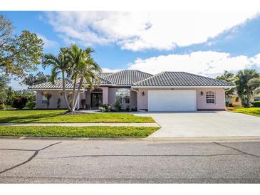 Single-story house with tile roof, two-car garage, and landscaped yard at 521 Pennyroyal Pl, Venice, FL 34293