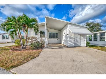 White mobile home with carport and landscaped yard at 552 Fleetwood St, North Port, FL 34287