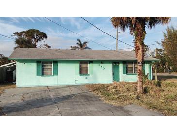 Light teal single story home with a driveway and mature landscaping at 810 Texas St, Englewood, FL 34223
