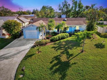 Attractive light blue house with a well-manicured lawn and driveway at 1237 Schooner Ln, Venice, FL 34285