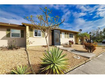 Tan house with green shutters, landscaping, and a walkway at 1953 Settlement Rd # 14, Venice, FL 34285