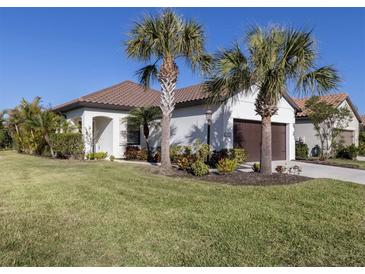 Single-story home with tile roof, two palm trees, and a well-manicured lawn at 205 Carlino Dr, Nokomis, FL 34275