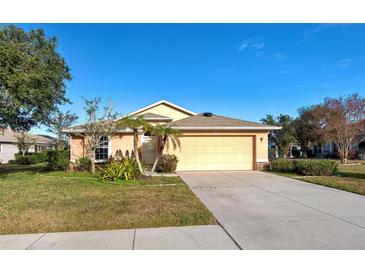 One-story house with attached garage, landscaping, and a driveway at 2134 Boxwood St, North Port, FL 34289