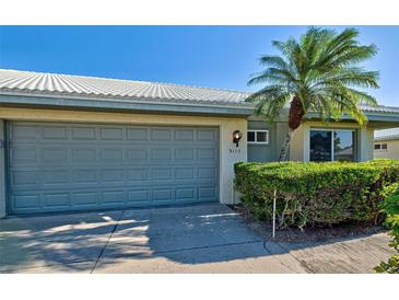 Gray double-car garage with a lush green hedge at 3117 Heron Shores Dr, Venice, FL 34293