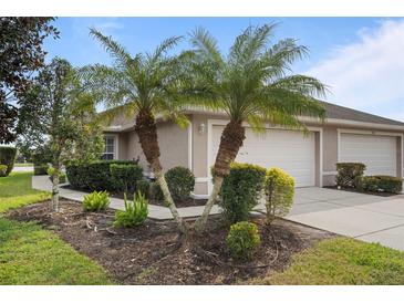 Front exterior view of villa with two palm trees and attached garage at 3789 Lakewood Blvd, North Port, FL 34287