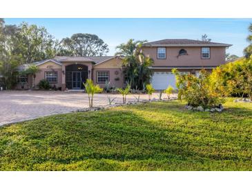 Two-story house with a large driveway and landscaped yard at 690 Percheron, Nokomis, FL 34275