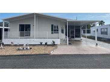 Mobile home exterior with covered porch and landscaped yard at 723 Locarno Dr, Venice, FL 34285