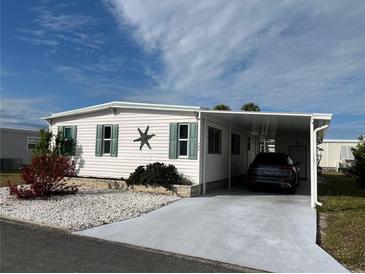 White single-wide manufactured home with carport and landscaped yard at 788 Cervina Dr, Venice, FL 34285