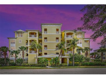 Beautiful yellow building exterior with palm trees at 10501 Amberjack Way # 103, Englewood, FL 34224