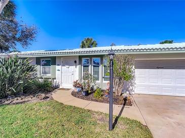 Florida home with landscaped yard, attached garage, and walkway at 18 Oakwood N Dr # 18, Englewood, FL 34223