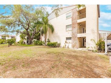 Two-story building with balconies, landscaping, and ample parking at 2280 Stickney Point Rd # 437, Sarasota, FL 34231