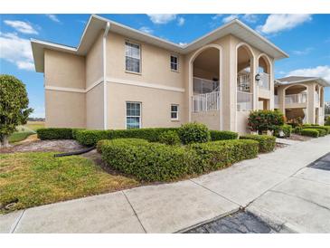 Tan two-story building with covered entryways and manicured landscaping at 5800 Sabal Trace Dr # 501, North Port, FL 34287