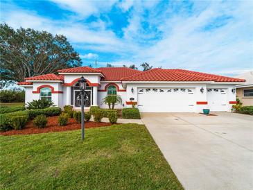 Single-story home with red tile roof, white walls, and a two-car garage at 1035 Beckley Cir, Venice, FL 34292
