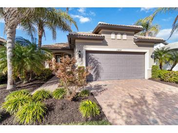 Single-story home with gray garage door and landscaped yard at 13864 Posada St, Venice, FL 34293