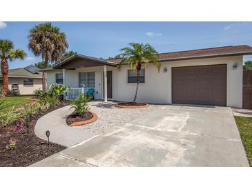 House exterior featuring a landscaped yard, driveway, and attached garage at 140 Columbia Rd, Venice, FL 34293