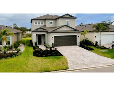 Beautiful two-story home featuring manicured landscaping, brick driveway, and a two-car garage at 1920 Sunset Preserve Way, Port Charlotte, FL 33953