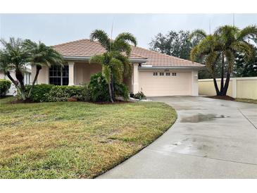 Single-story home with attached garage and manicured lawn at 2890 Whispering Pine Ln, North Port, FL 34287