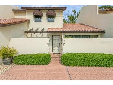Front view of a charming condo with a terracotta roof and gated entryway at 440 Palmetto Ct # 3, Venice, FL 34285