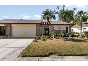 Cute two-bedroom villa with attached garage and landscaped yard at 664 Linden Dr, Englewood, FL 34223