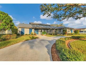 Single-story home with blue shutters, landscaping, and a curved driveway at 700 Valencia Rd, Venice, FL 34285