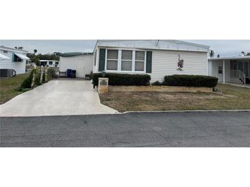 Single-wide manufactured home with carport and landscaped yard at 863 Baveno Dr, Venice, FL 34285