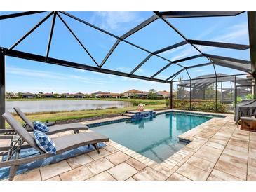 Screened pool and patio area with lounge chairs overlooking a lake at 9895 Wingood Dr, Venice, FL 34292