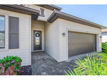 Two-story house with gray garage door and landscaped yard at 11165 Balfour St, Venice, FL 34293