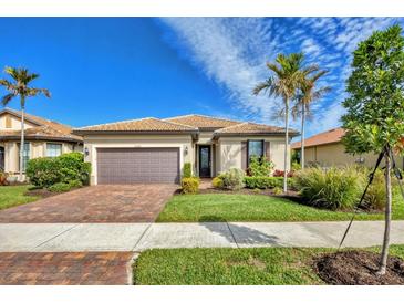 Single-story home with brown garage door, landscaping, and palm trees at 13836 Karina St, Venice, FL 34293