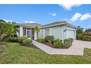 Light teal house with a screened porch, two-car garage, and nicely landscaped yard at 1630 Monarch Dr, Venice, FL 34293