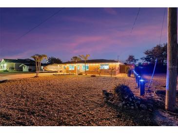 Single-story home with brick paver driveway and boat parking at dusk at 1985 Fairview Dr, Englewood, FL 34223