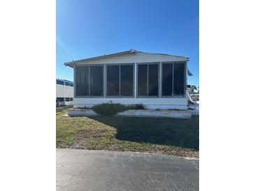 White single-wide manufactured home with screened porch at 199 Palm Air Dr, Osprey, FL 34229