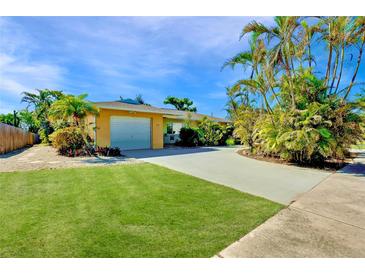 Charming single story home with a large grassy yard, driveway, and lush landscaping at 237 San Marco Dr, Venice, FL 34285