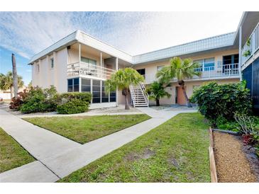 Two-story condo building with landscaped grounds and walkway at 460 Base E Ave # 122, Venice, FL 34285