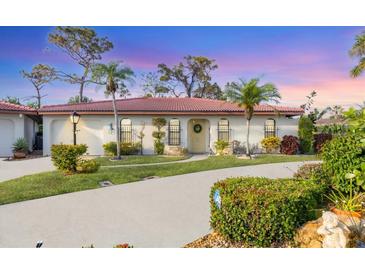 Single-story home with a tile roof, landscaped yard, and a paved driveway at 858 Senda Plata # 20, Venice, FL 34293
