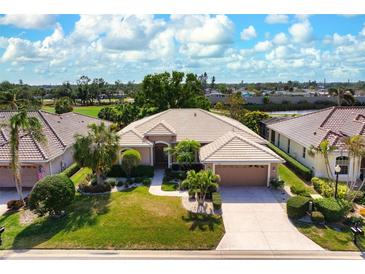 Aerial view of a single-story house with a tile roof, landscaping, and a two-car garage at 1018 Grouse Way, Venice, FL 34285