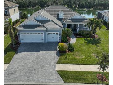 Single-story home with gray siding, three-car garage, and landscaped lawn at 12353 Auburndale Ct, Venice, FL 34293