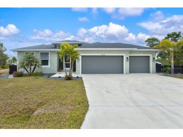 Single-story home with three-car garage and landscaped yard at 14098 Baracoa Ln, Port Charlotte, FL 33981