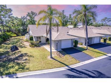 Charming one-story home featuring an attached garage, mature landscaping, and a well-maintained lawn at 301 Pinebrook Club Dr # 1, Venice, FL 34285