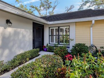 Inviting exterior with landscaped walkway, lush greenery, and a charming entrance at 341 Pembroke Ln # 227, Venice, FL 34293