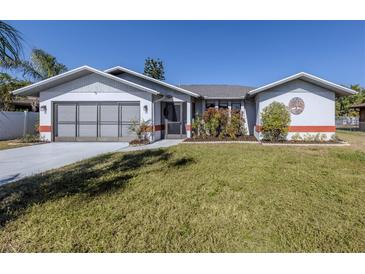 Single-story home with attached garage and well-manicured lawn at 4060 Barbary Ln, North Port, FL 34287