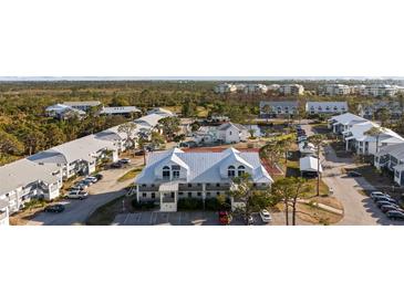 Aerial view of a community with multiple buildings, tennis courts, and a pond at 6800 Placida Rd # 280, Englewood, FL 34224