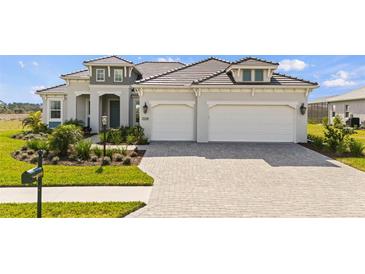 Beautiful two-story home featuring a three-car garage and lush landscaping at 11140 Hogan Cir, Englewood, FL 34223